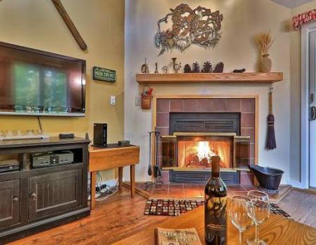 a warm gas-powered fireplace against a white wall beneath a tan, wooden mantel