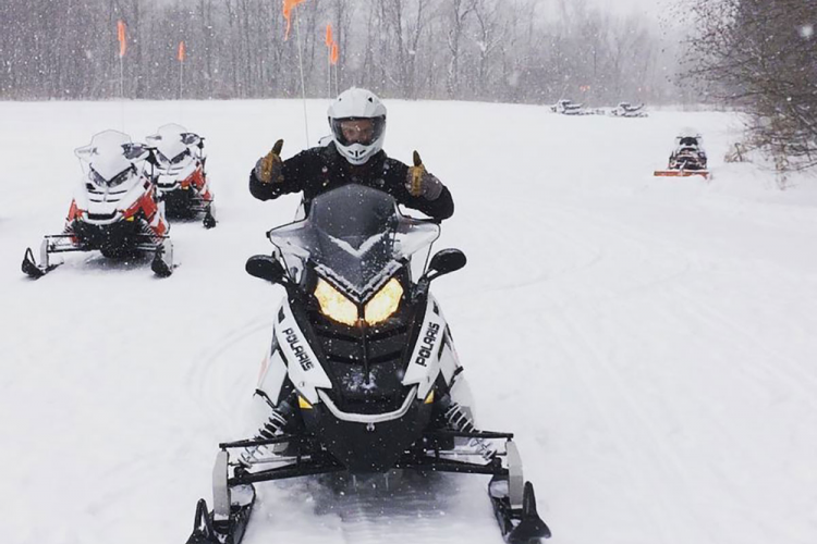 a person on a snowmobile gives two thumbs up
