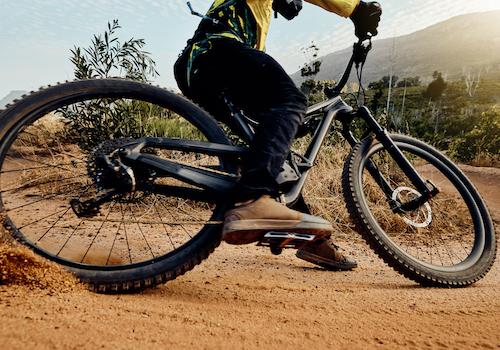 close up of a mountain bike and rider making a tight turn on a trail