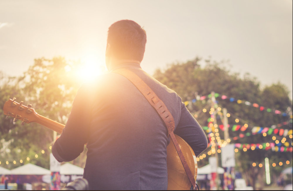 man playing music at outdoor festival