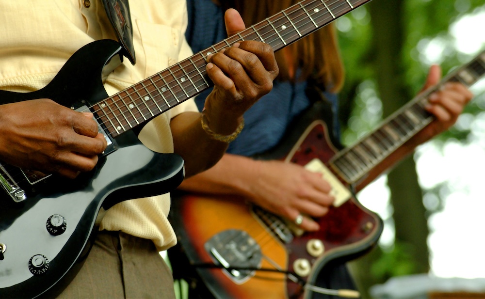 two people on stage playing guitars 